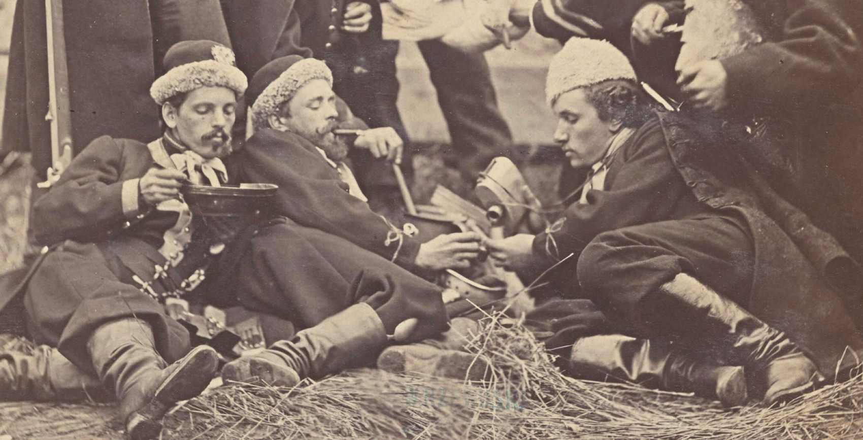 Powstańcy styczniowi, trzej mężczyźni leżą na trawie i odpoczywają.  Jeden z nich (w środku) pali fajkę.
