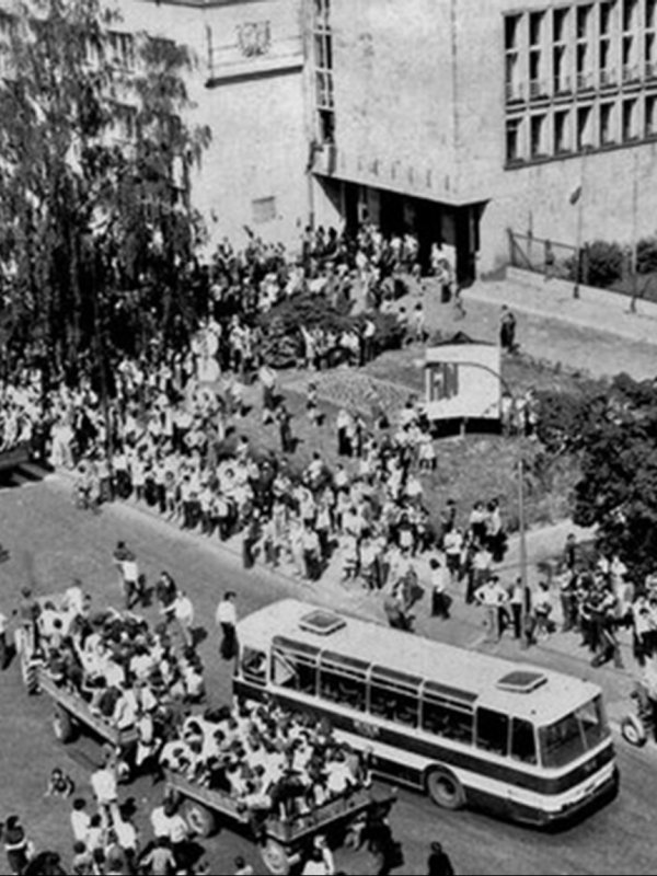 Tłum ludzi, przyczepy przy traktorze, autobus