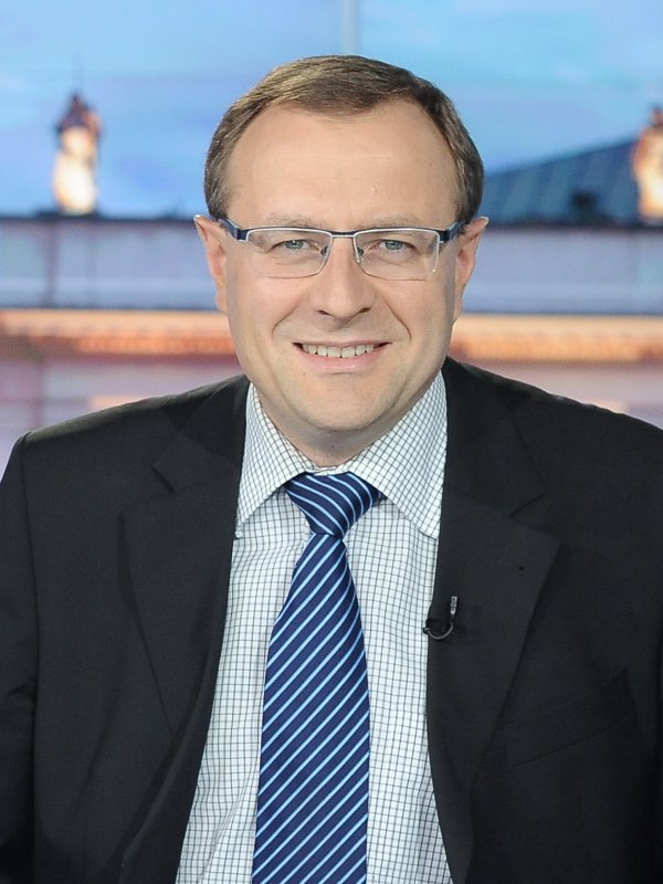 Uśmiechnięty mężczyzna w okularach w garniturze z granatowym krawatem w prążki