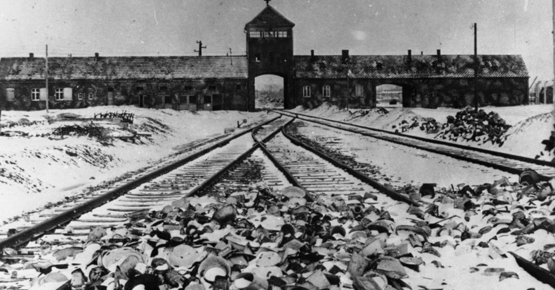Tory kolejowe, wartownia i brama główna Auschwitz II (Birkenau), widok z rampy wewnątrz obozu, 1945, Wikipedia / Railway tracks, the guard house and the main entrance gate of Auschwitz II (Birkenau), a view from a ramp inside the camp, 1945, Wikipedia