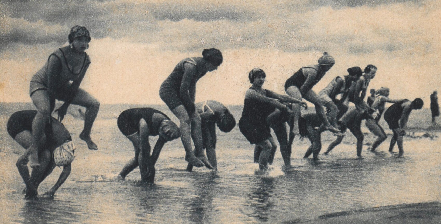 kobiety skaczące przez morskie fale