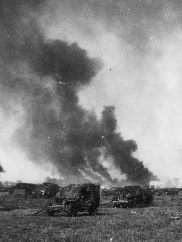 ! Dywizja Pancerna podczas walk w Belgii, 1944 rok.  Na zdjęciu samochody pancerne i unoszący się nad polem bitwy dym.