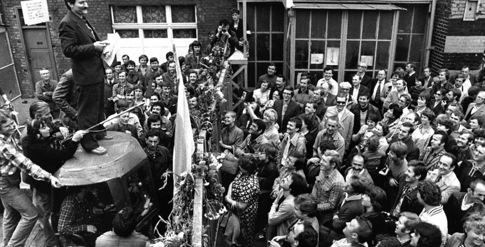 Lech Wałęsa, przywódca strajku gdańskich stoczniowców, stojąc na wózku, przemawia do sympatyków strajku zebranych pod bramą nr 1 Stoczni Gdańskiej