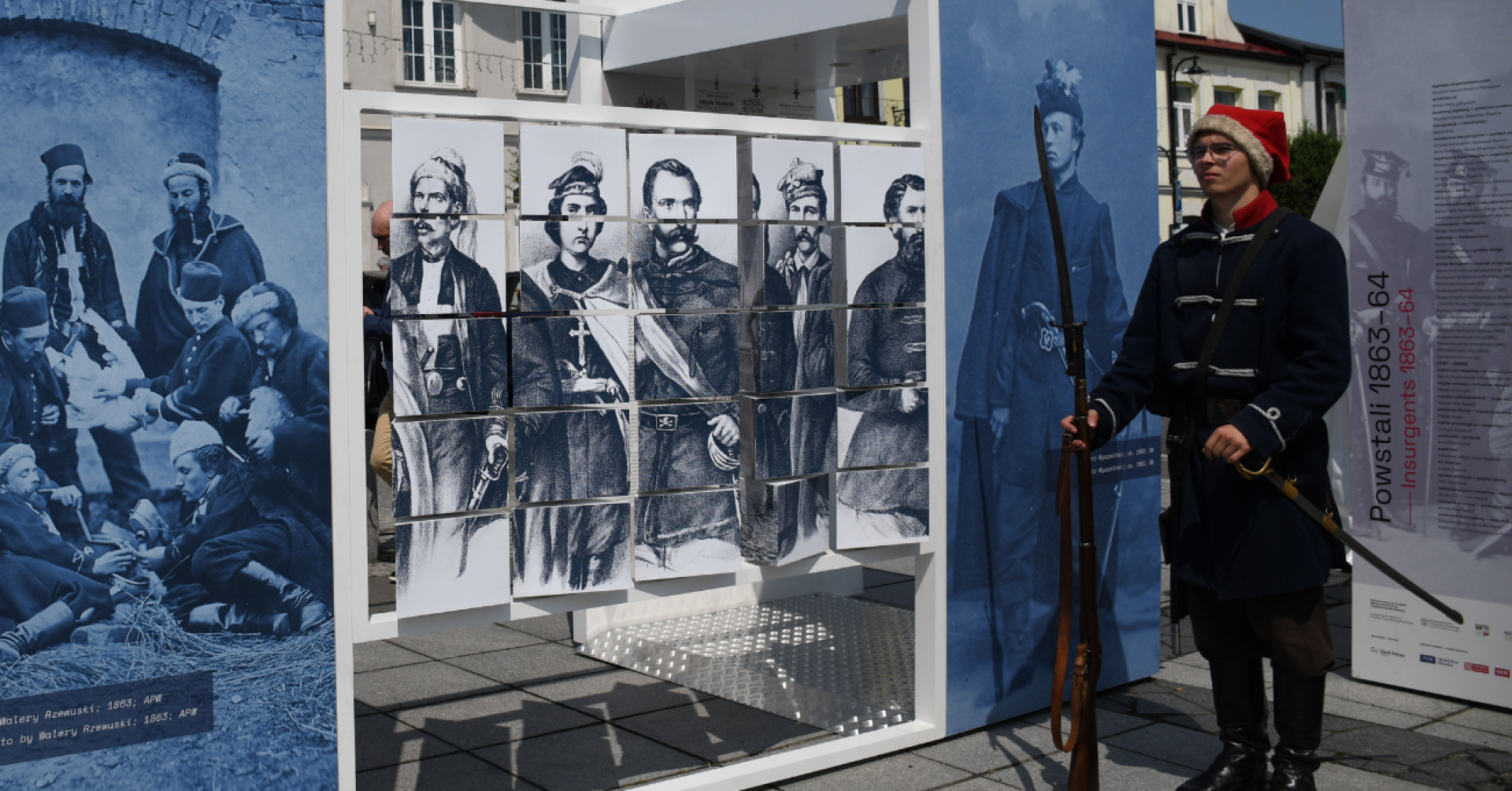 Detal wystawy "Powstali 1863-64". Po prawej stronie młody mężczyzna w stroju z czasów powstania.