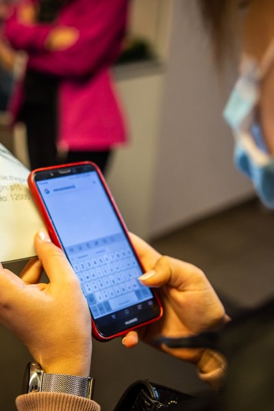 zdjęcie osoba w maseczce korzystająca z telefonu