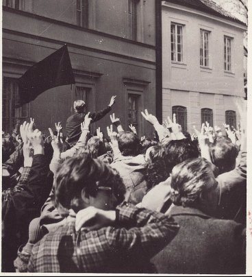 Tłum protestujących na ulicach miasta, w tle kamienice