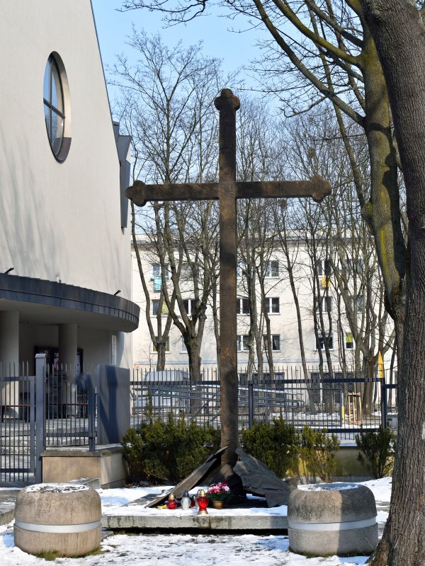 Krzyż przy ogrodzeniu otaczającym kościół.