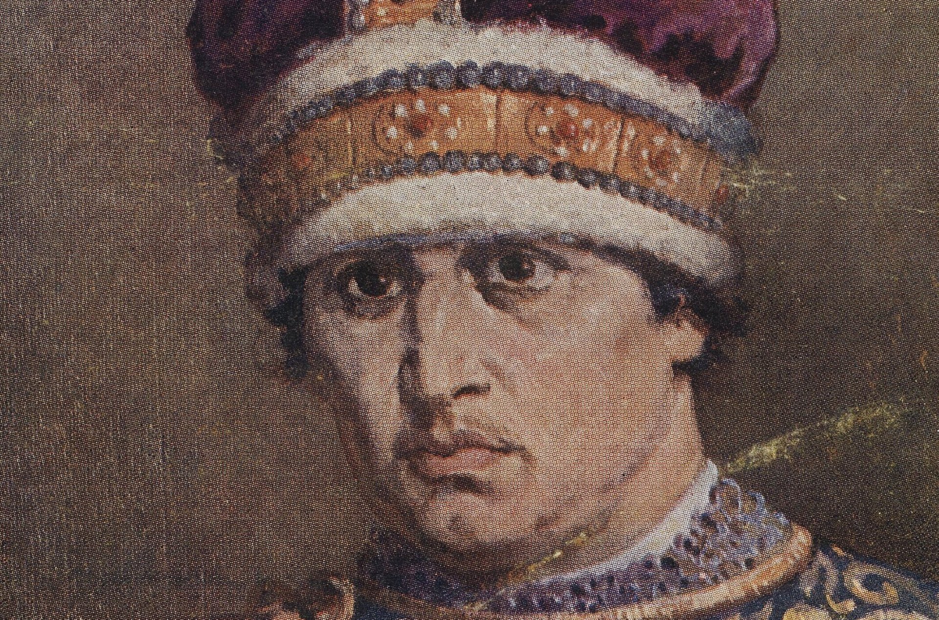 Młody mężczyzna z brązowymi włosami i oczami w nakryciu głowy ozdobiony, kamieniami szlachetnymi