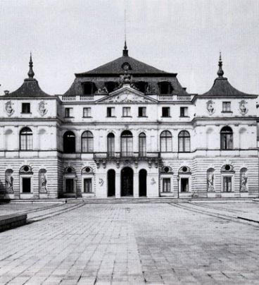 Czarno-biała fotografia pałacu o trzech kondygnacjach.