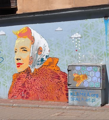 Mural przedstawiający rudowłosą kobietę z ustami umalowanymi na czerwono, w rudym futrze i w jasnej chustce na głowie, z lewej strony zdjęcia: podpis Hanka Ordonówna