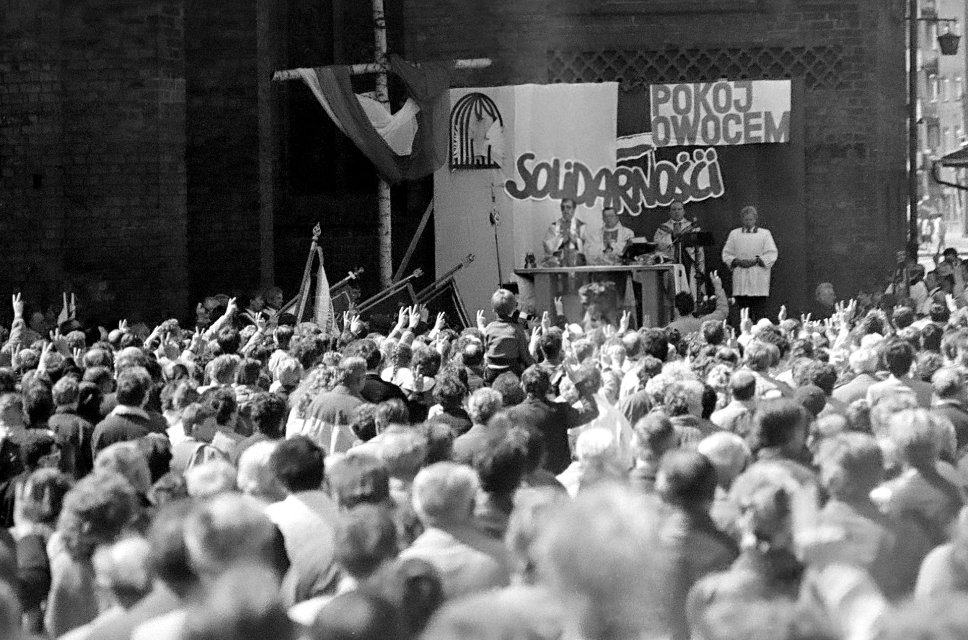 Msza z tłumem wiernych. Za ołtarzem napis: „Pokój owocem Solidarności”.