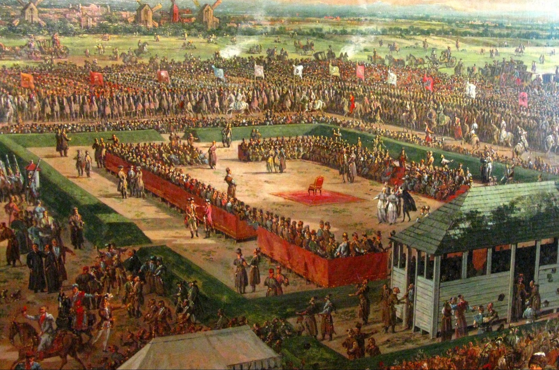 Pole elekcyjne z zielonym pawilonem, otoczone równo przystrzyżonym zielonym żywopłotem i obradującymi ustawionymi w czworobok