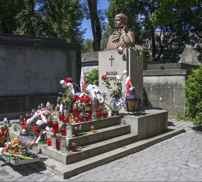 Przyozdobiony kwiatami i lampkami grób z popiersiem pisarki
