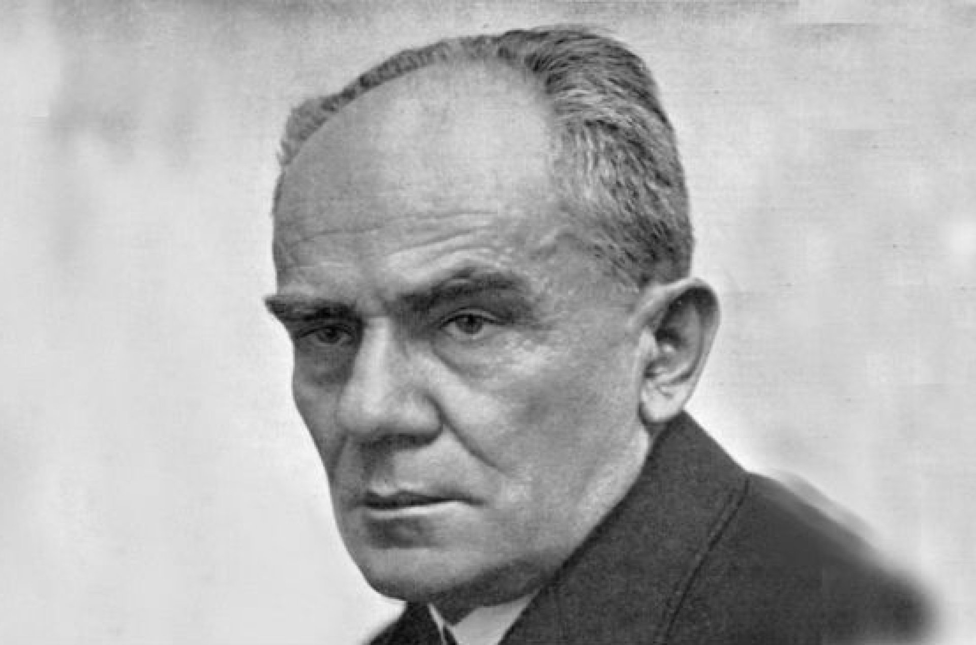 Starszy mężczyzna z wyrazistymi brwiami i łysiną z przodu głowy