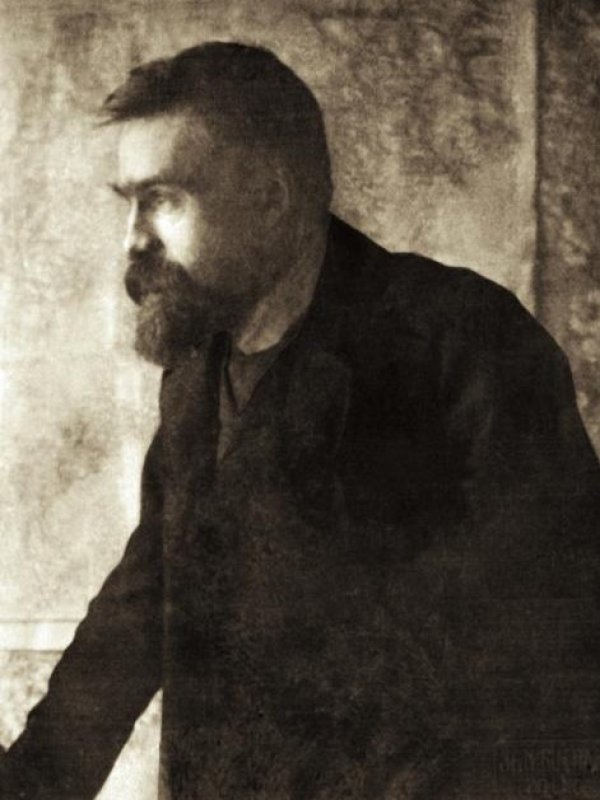 Zdjęcie przedstawia młodego Piłsudskiego z profilu, z wąsami i bujną brodą.  