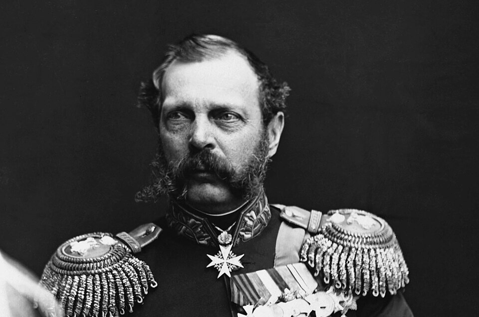 Mężczyzna z długimi wąsami i bokobrodami w mundurze z odznaczeniami i epoletami.