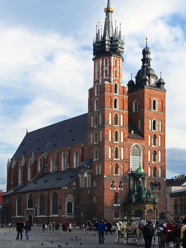 Fasada kościoła mariackiego z dwoma strzelistymi wieżami. Przed kościołem widoczne grupy turystów.