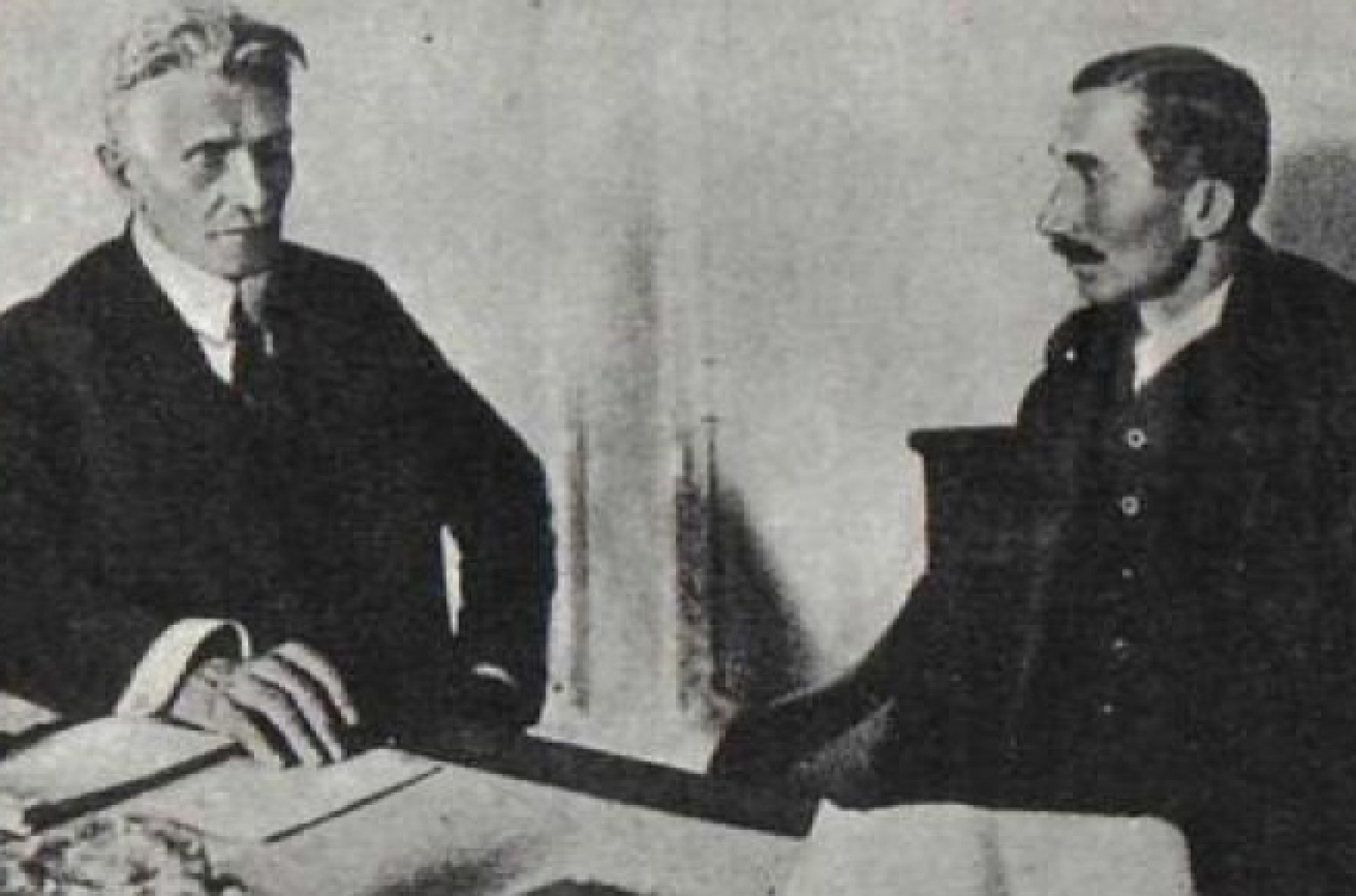 Czarno białe zdjęcie gazetowe. Po lewej stronie siedzi siwy mężczyzna z wąsami (Daszyński), a po prawej - młodszy mężczyzna z ciemnymi krótszymi włosami i wąsami (Witos).