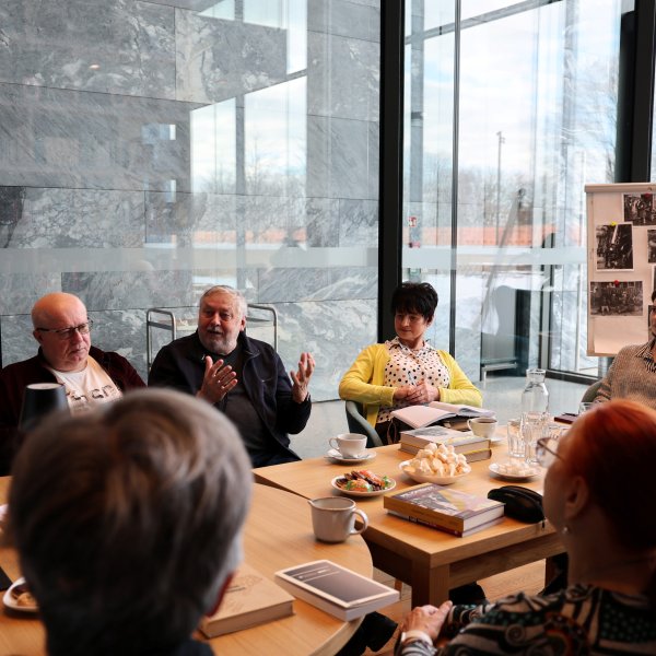 Uczestnicy klubu rozmawiający przy stole